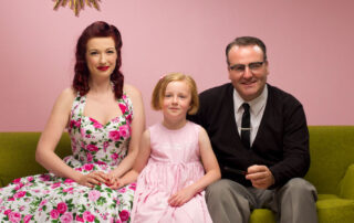 a 1950s family sits on a sofa