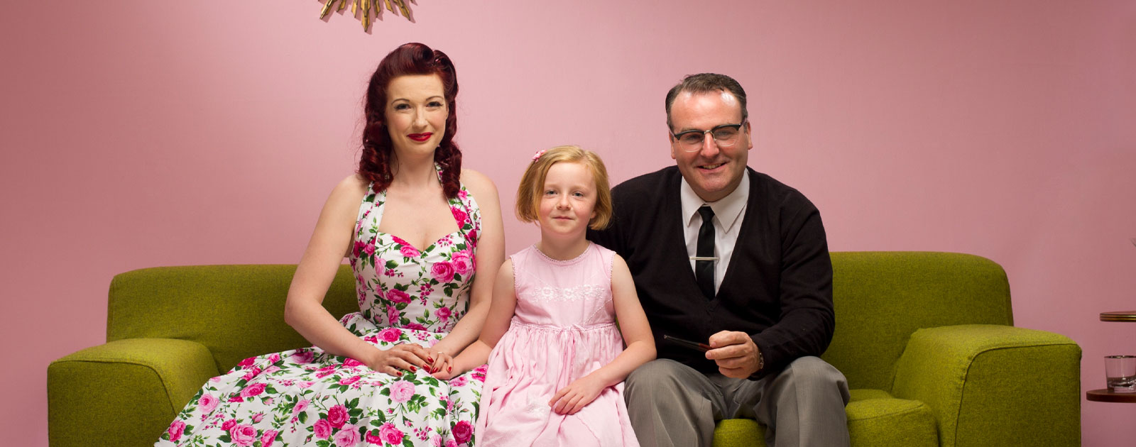 a 1950s family sits on a sofa